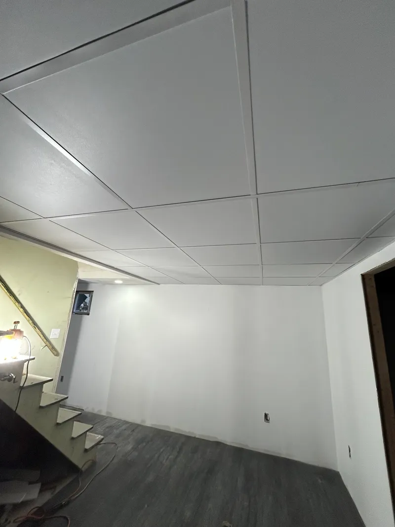 Suspended ceiling installation near a stairwell by Mass Framing Solutions