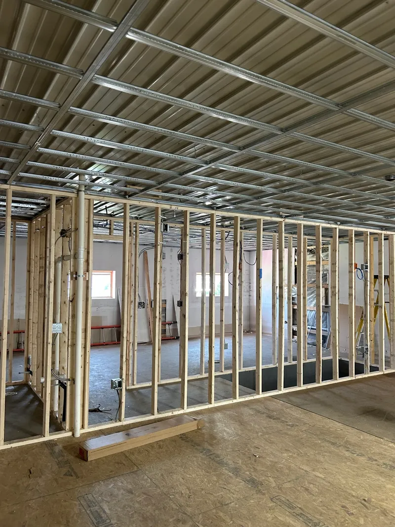 Interior wall framing and ceiling grid ready for drywall, installed by Mass Framing Solutions